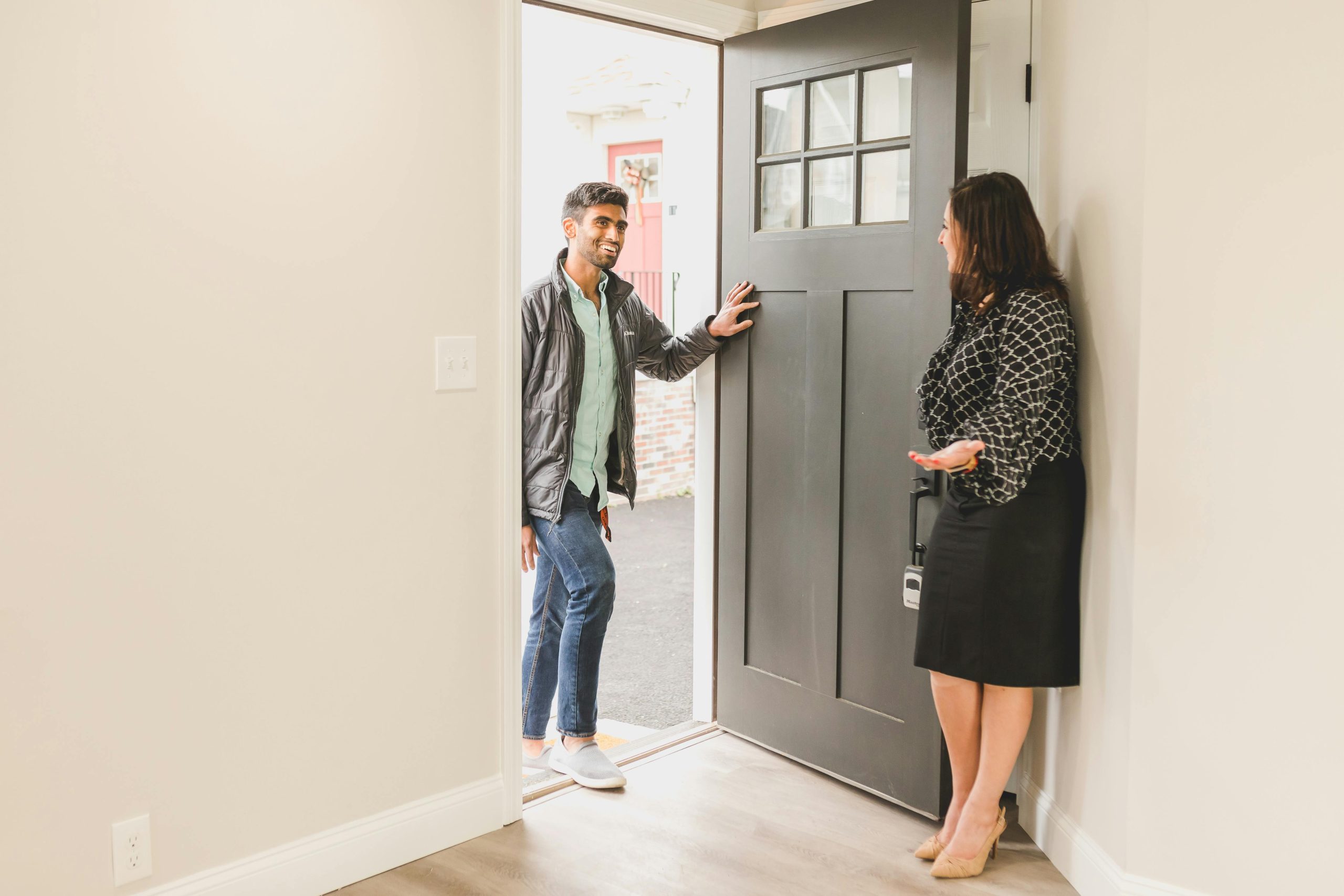 woman welcoming a potential client into a house for sale